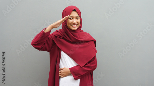 Bilde på lerret Asian hijab woman salutes to commemorate Independence Day