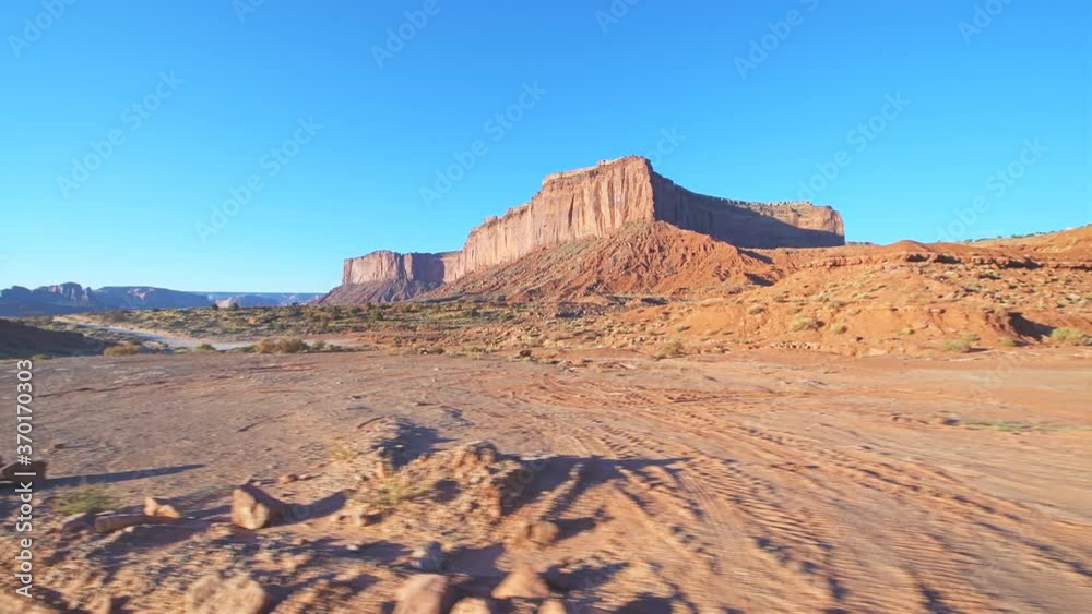 Famous scenic rock formations landscape view from road trip driving pov in summer in Monument Valley, Arizona in North America, USA with butte mesa rocks in morning sunlight sunrise Famous scenic rock formations landscape view from road trip driving pov in summer in Monument Valley, Arizona in North America, USA with butte mesa rocks in morning sunlight sunrise