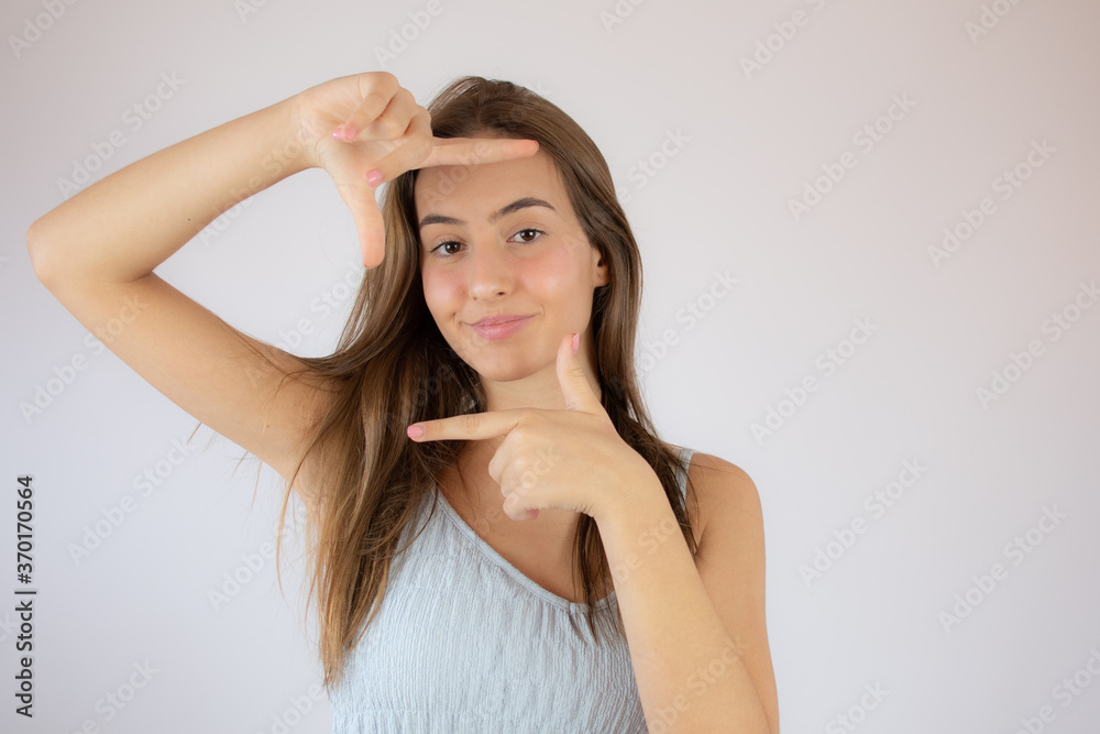 Pretty young girl making the portrait gesture