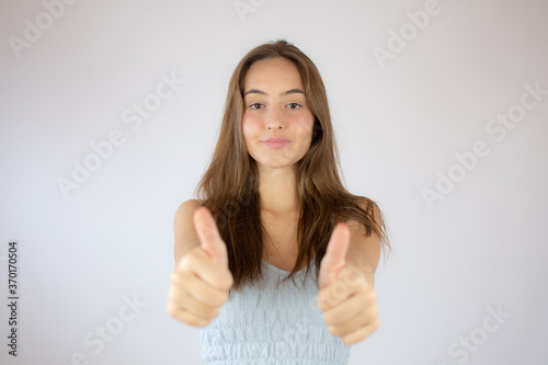 Pretty young girl making fingers up gesture © Danko