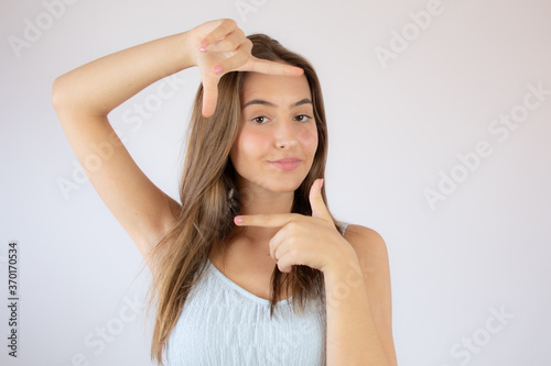 Pretty young girl making the portrait gesture