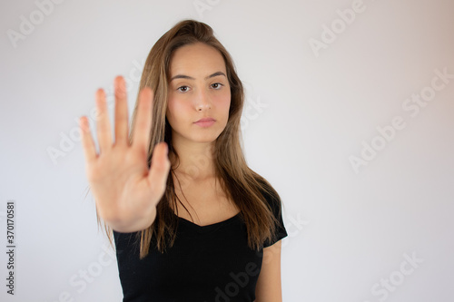 Pretty young girl making stop hand gesture