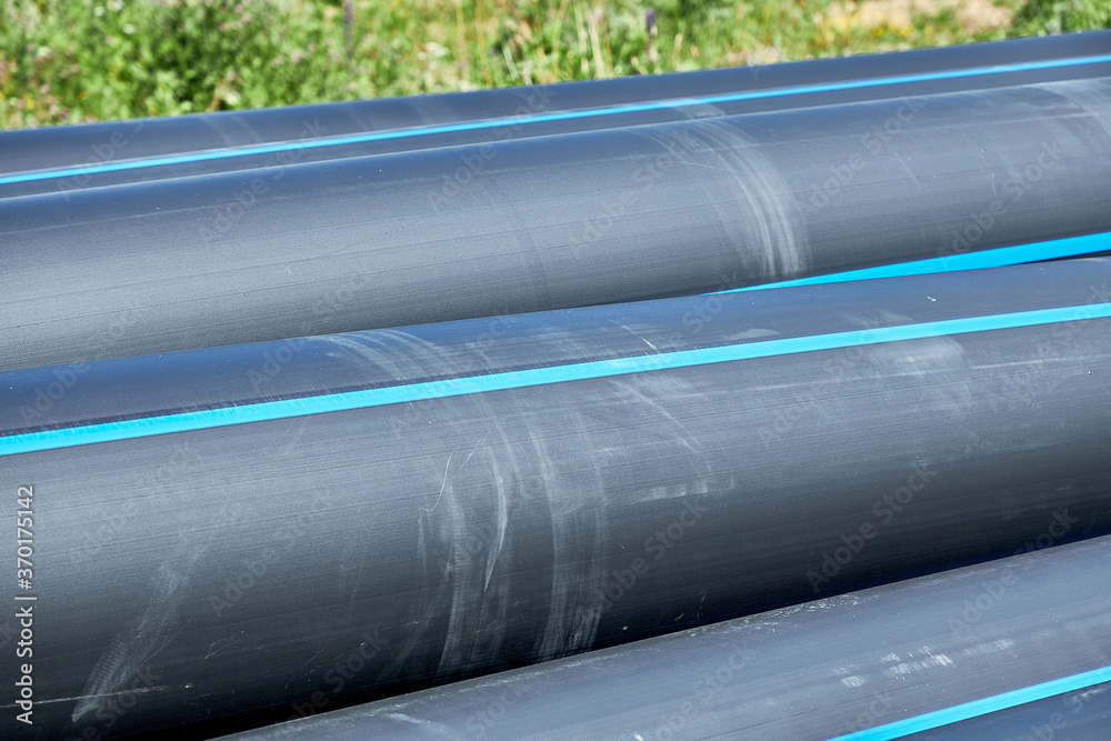 A lot of polyethylene pressure pipes lying outdoors during installation