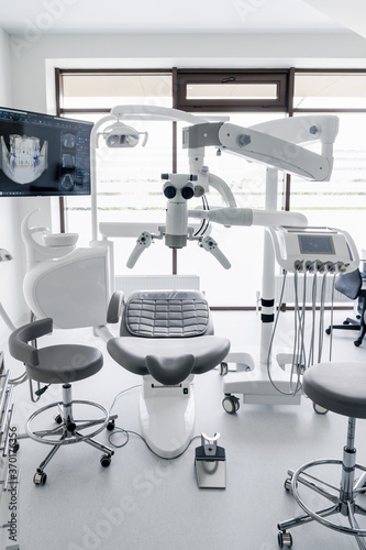 Interior of dental practice room with chair  lamp  display and stomatological tools