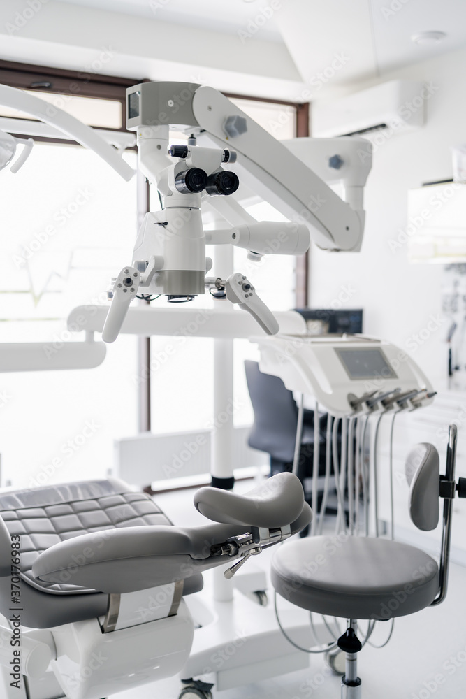 Interior of dental practice room with chair, lamp, display and stomatological tools Interior of dental practice room with chair, lamp, display and stomatological tools