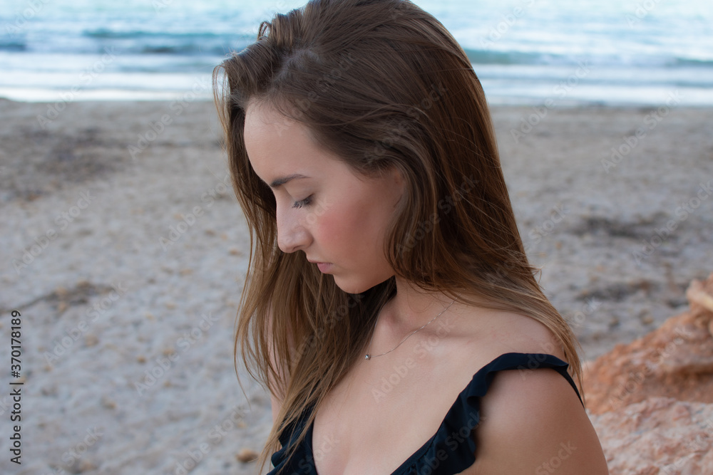 Profile portrait of a pretty girl on the beach