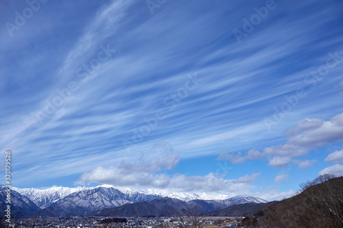 青空にすじ雲（巻雲）がたなびく冬の北アルプス連山 長野県大町市 © Nagawa