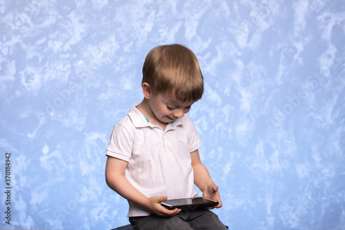 a three-year-old child sits with a smartphone in his hands and watches cartoons or plays. the concept of the prohibition of computer games and the negative impact on the psyche of children.