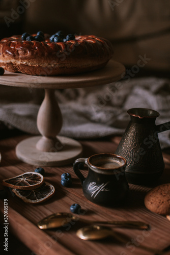 Still life of apple pie  berries  coffee and lemons on wooden tray