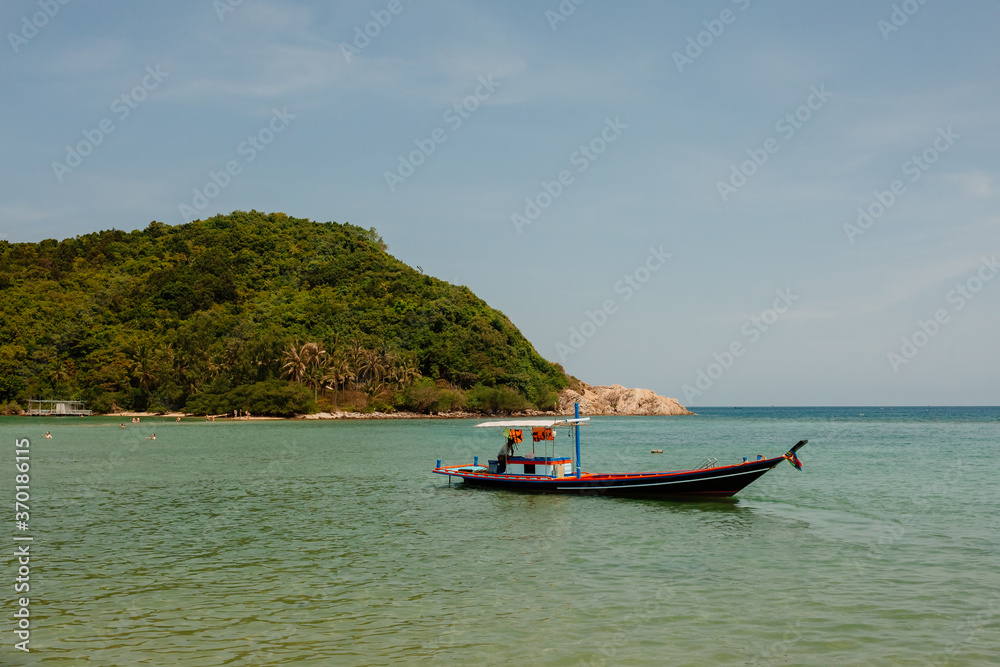 Tropical beach in Thailand with blue ocean, white sand and typical fishermen boat