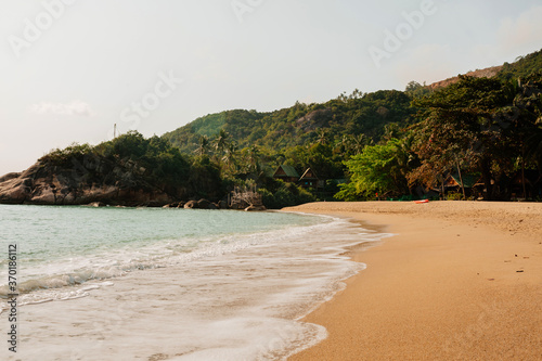 Tropical beach in Thailand with blue ocean, white sand and palms