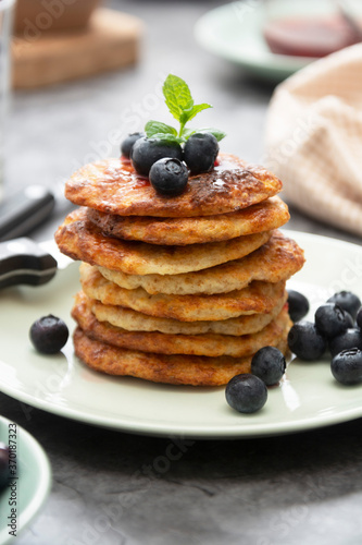 Homemade pancakes stack with blueberries, healthy breakfast food, dark background.