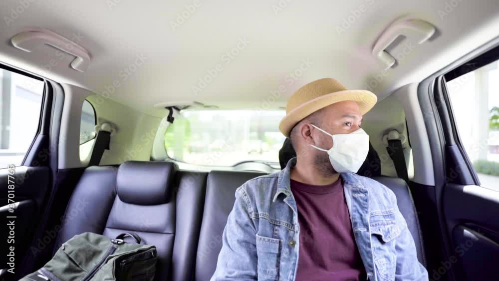Young asian backpacker traveling in urban city, He wearing face mask for protect virus air pollution on safety travel, He sitting inside the car and look around. Slow Motion Shot. Young asian backpacker traveling in urban city, He wearing face mask for protect virus air pollution on safety travel, He sitting inside the car and look around. Slow Motion Shot.