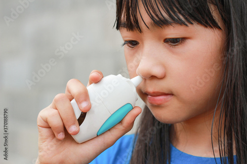 An Asian kid use nasal sray for rhinitis photo