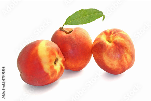 Three peaches with leaf isolated on white