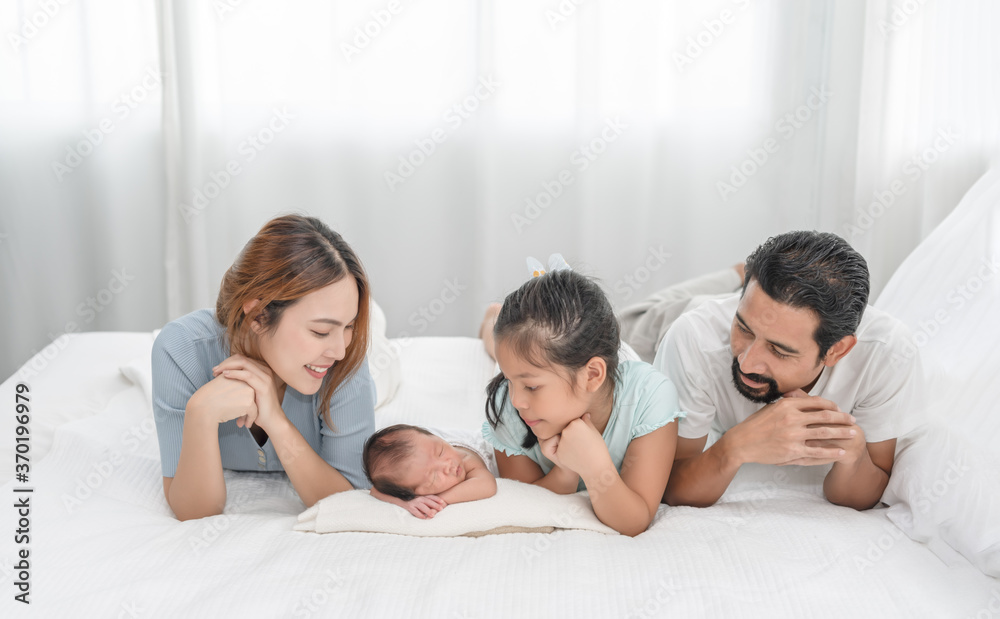 Parent and children relaxing together. Portrait of a young family with mother, father, son and daughter. Parents having happy time, welcoming newborn.