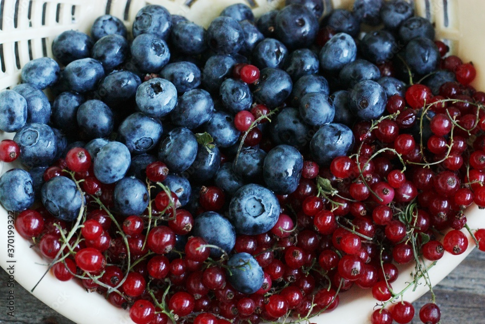 Fresh blueberries and red currants on the table Fresh blueberries and red currants on the table