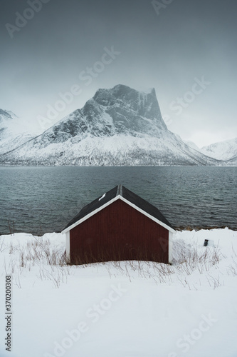 mountain hut in the snow by a lake