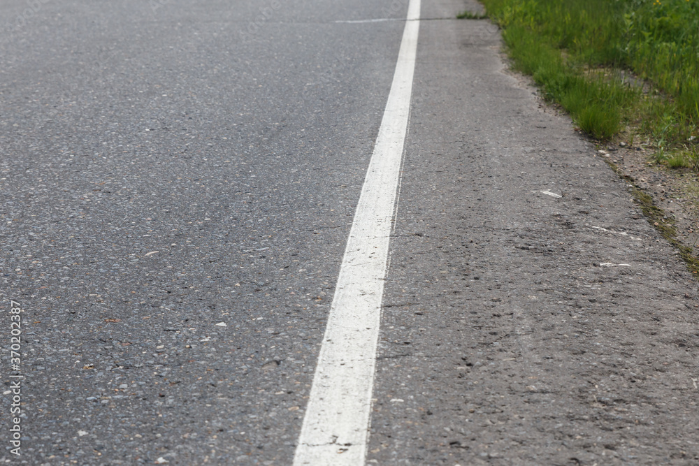 White solid line. Road marking on an asphalt road. selective focus White solid line. Road marking on an asphalt road. selective focus