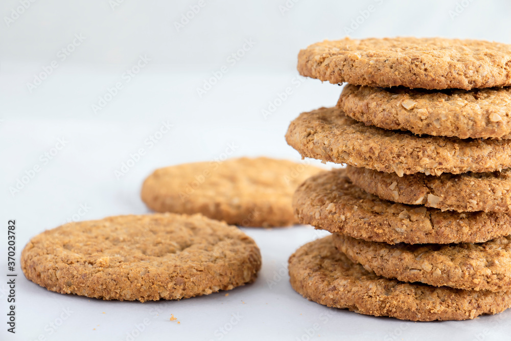 Homemade shortbread cookies made of oatmeal are stacked on a white table background. Food snack concept and with copy space for text.
