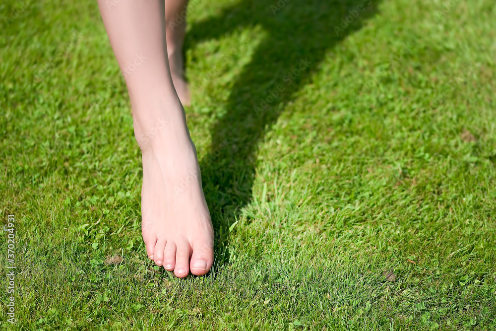 Bare feet of a young woman on green grass