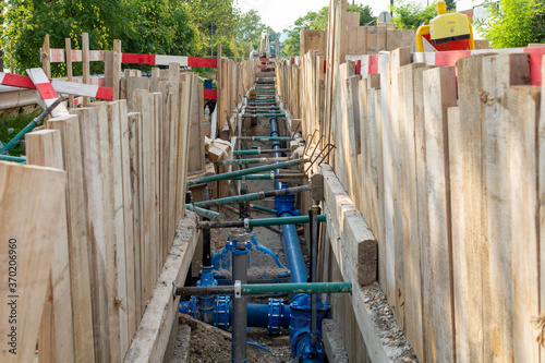 Repair of roads and underground utilities. Big trench on the road with a pipe, the process of repair, or replacing water pipes in a city.