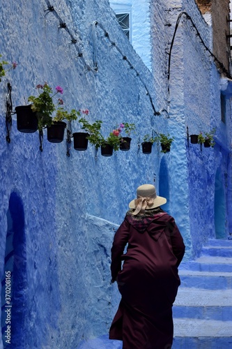 Woman walking in the incredible blue streets of Chefchaouen, the blue pearl of Morocco © Claudia