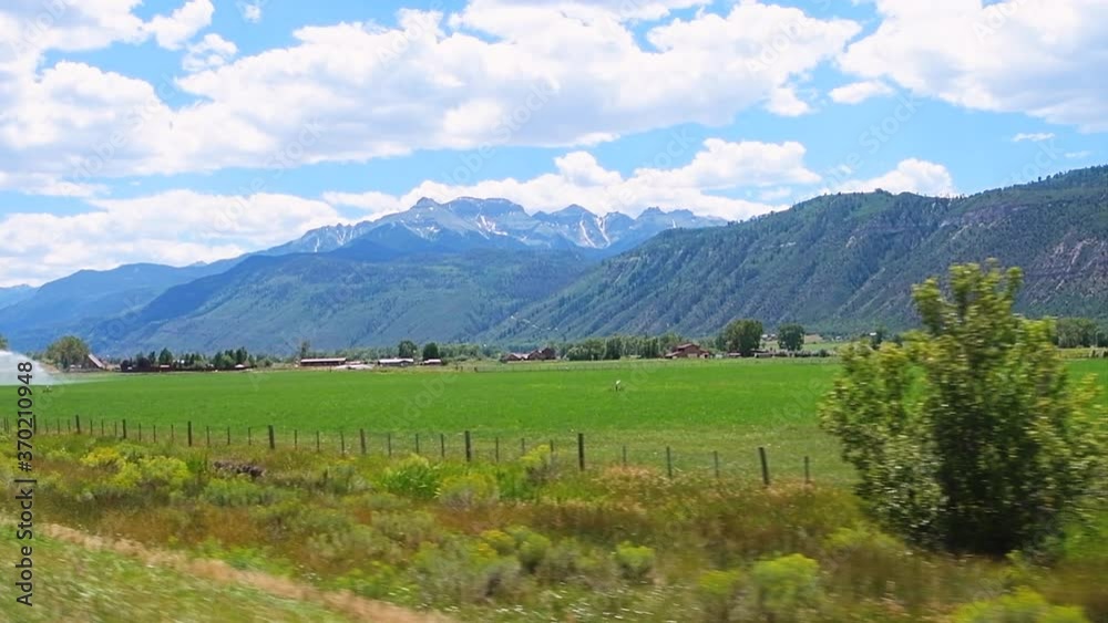 Slow motion pov point of view driving car vehicle shot of Gunnison county farm valley with farming agricultural field near Montrose, Colorado USA in summer Slow motion pov point of view driving car vehicle shot of Gunnison county farm valley with farming agricultural field near Montrose, Colorado USA in summer