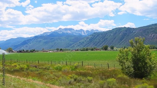 Slow motion pov point of view driving car vehicle shot of Gunnison county farm valley with farming agricultural field near Montrose, Colorado USA in summer photo