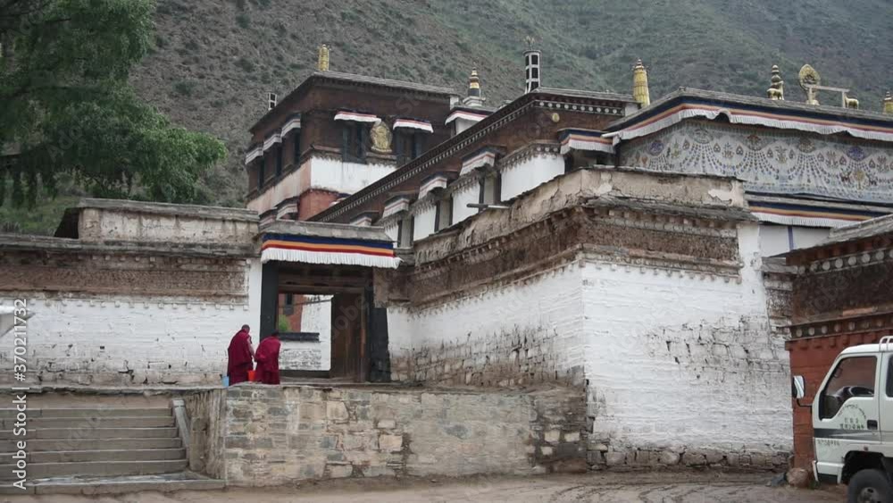 Monks walking home next to Tibetan buddhist monastery in Xiahe, China Monks walking home next to Tibetan buddhist monastery in Xiahe, China