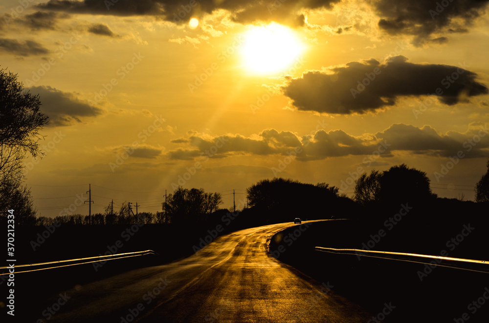 The road in the rays of a bright sunset
