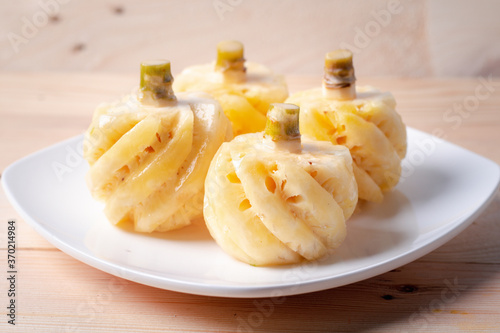 Phulae pineapple on a plate on a wooden background