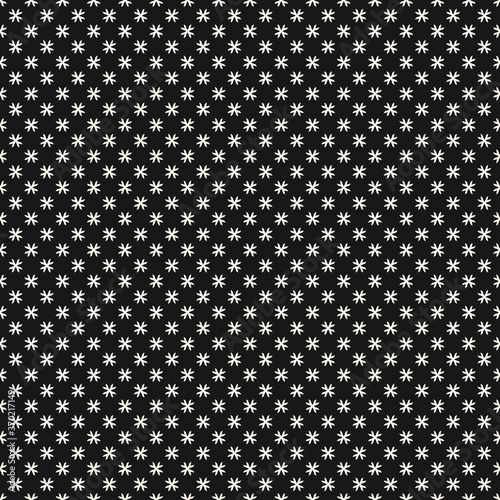 Vector geometric floral pattern. Ornamental seamless texture in ethnic style. Abstract monochrome ornament with small flower shapes, tiny crosses, stars. Black and white background. Dark repeat design