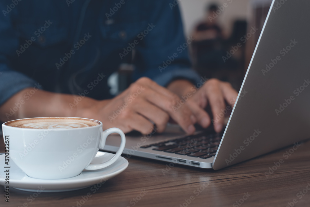 Casual business man or freelancer online working on laptop computer in coffee shop