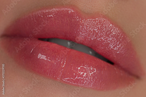 Sexual beautiful full lips. Natural gloss of lips and woman s skin. The mouth is closed. Increase in lips  cosmetology and spa. Great summer mood and Pink lipstick. Skin care