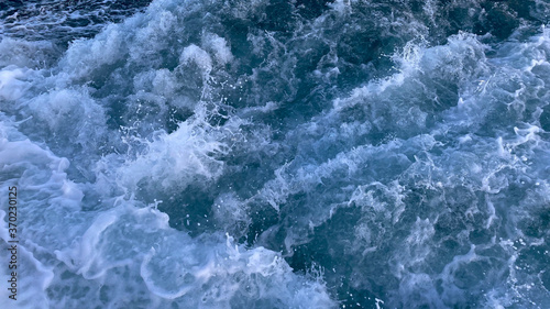 Seawater surface. White foam waves texture as a natural background.