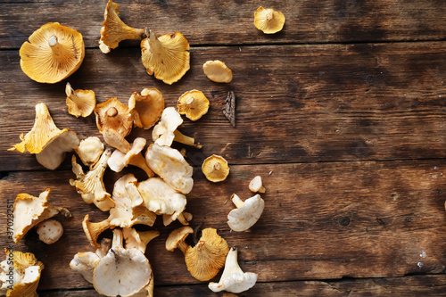 Foto Chanterelle mushrooms scattered on a wooden table