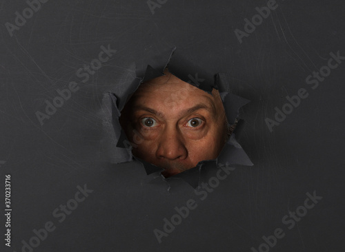 man portrait in black paper hole photo