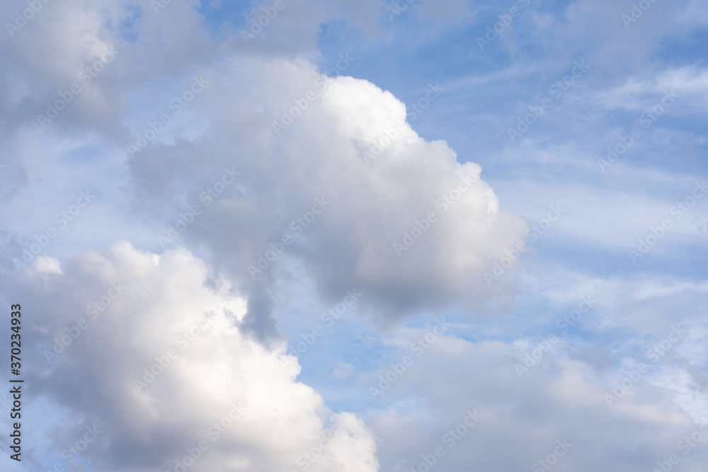 Blue summer sky with a lot of white fluffy cumulus clouds. Natural background made of cloudscape with sunlight. Blue summer sky with a lot of white fluffy cumulus clouds. Natural background made of cloudscape with sunlight.