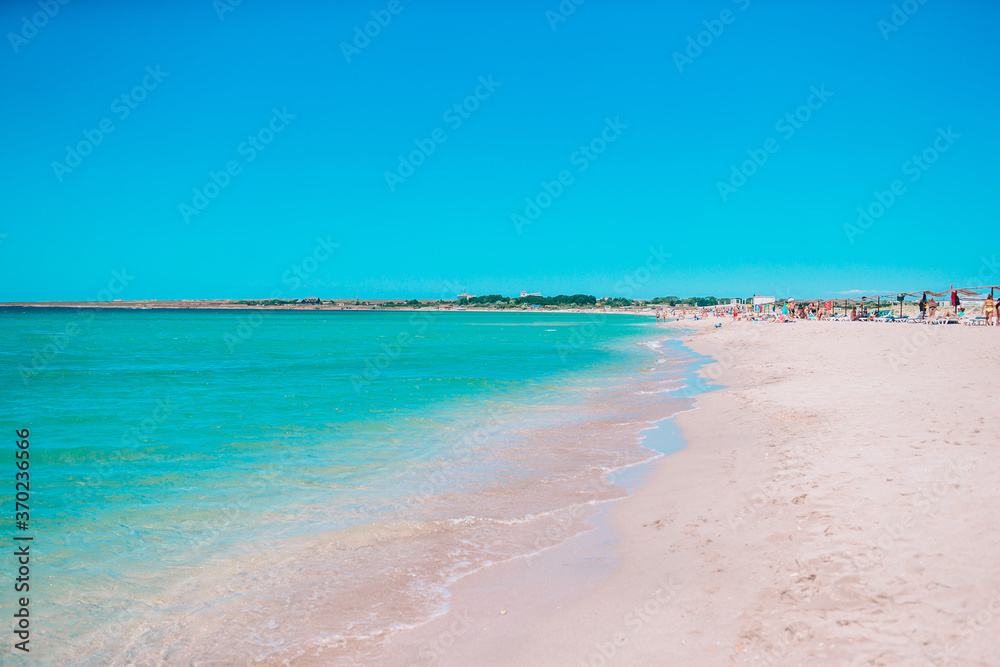 Idyllic tropical beach with white sand, turquoise ocean water and beautiful colorful sky