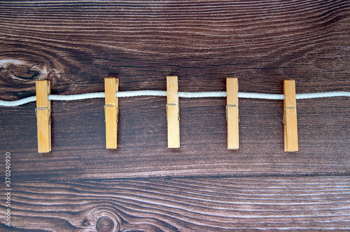 Clothespins on rope and empty vintage wooden planks background. Close up macro.