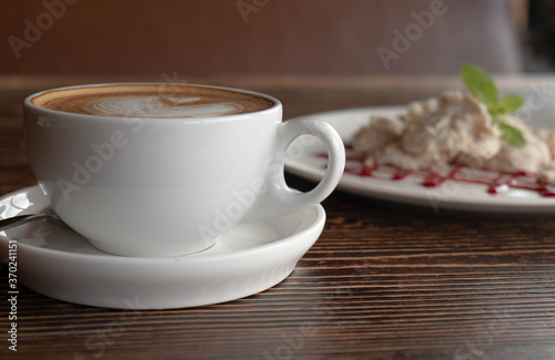 a white ceramic cup of cappucino as a coffee break concept