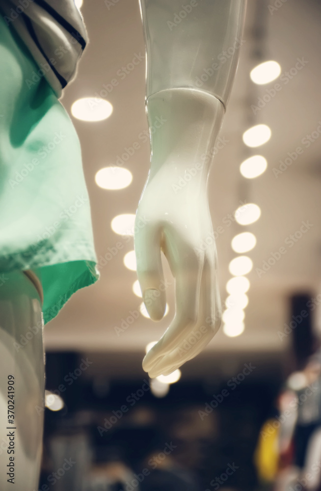 Closeup plastic mannequin hand in department store, fashion boutique, supermarket or showroom, with bright illumination in the background