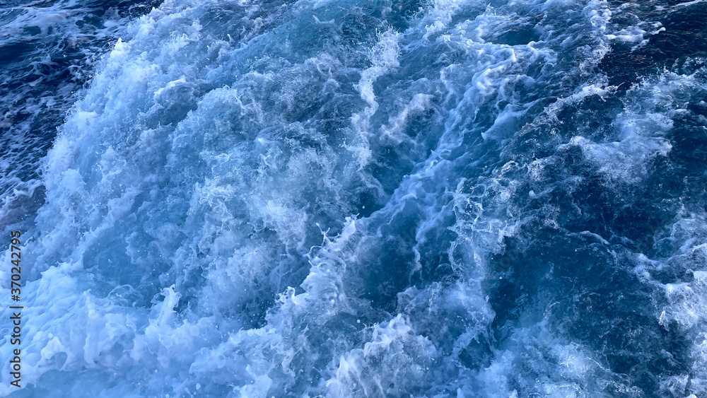 Seawater Ocean surface, sea foam on the blue ocean, background.