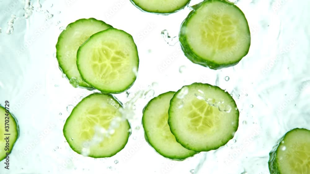 Super Slow Motion Shot of Cucumber Slices Falling into Water on White Background at 1000fps. Super Slow Motion Shot of Cucumber Slices Falling into Water on White Background at 1000fps.