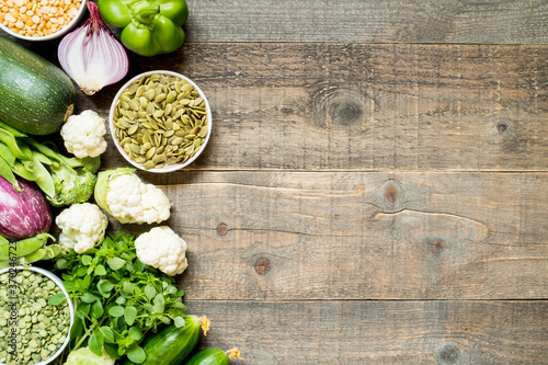 Top view set raw of green and purple vegetables and protein for vegetarians spread on dark wooden background. Copy space.