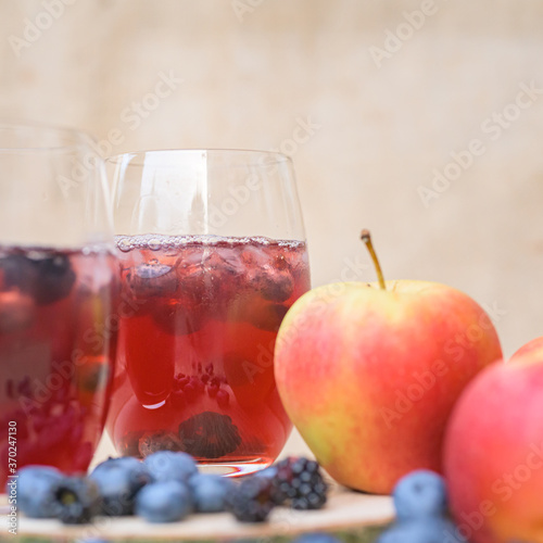 delicious red berries Cocktail with blueberries in front of a blurred brown background