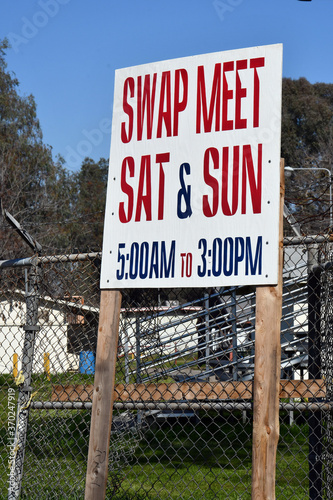 A swap meet sign telling the hours