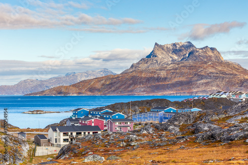 Inuit houses and cottages scattered across tundra landscape in residential suburb of Nuuk city with fjord and mountains in the background, Greenland photo