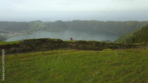 Cinematic Reverse Aerial Of Tourists Standing At Sete Cidades Crater, Azores photo